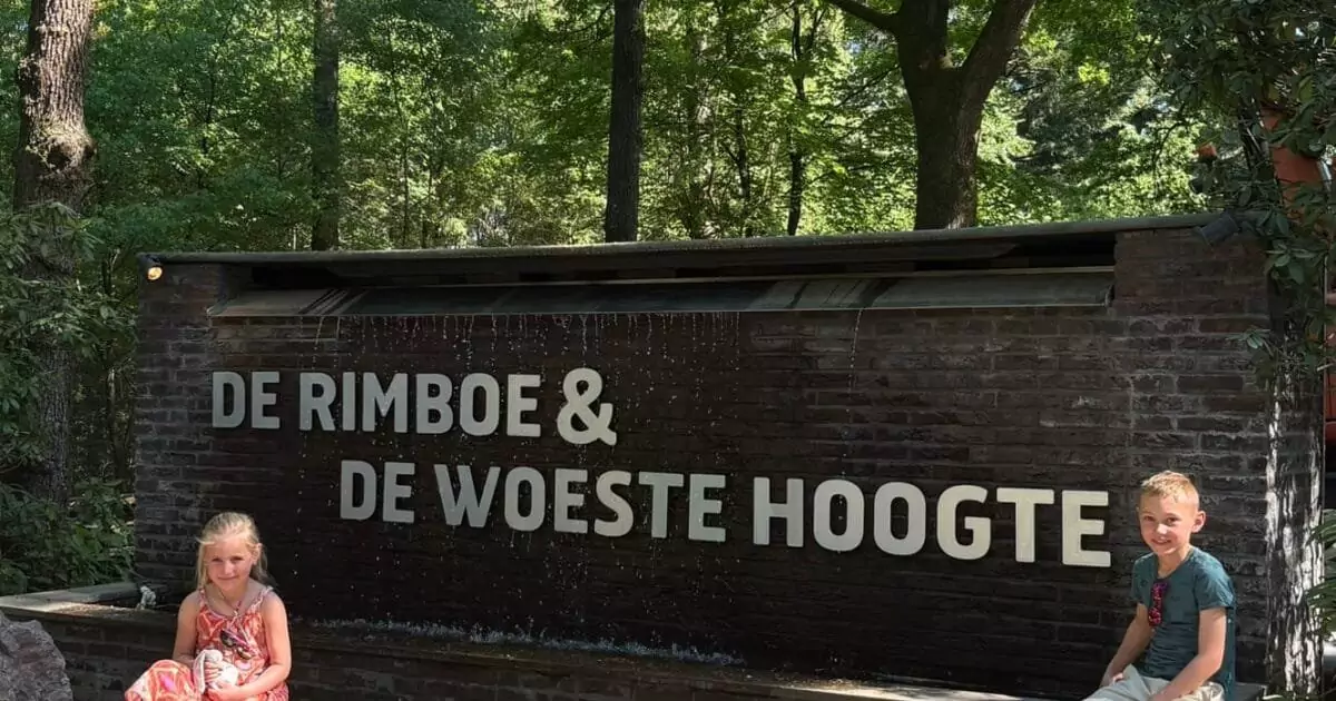 Kinderen bij het bord van Park De Rimboe & De Woeste Hoogte in Hoenderloo