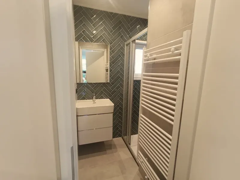 Badkamer met douche en groene visgraattegels