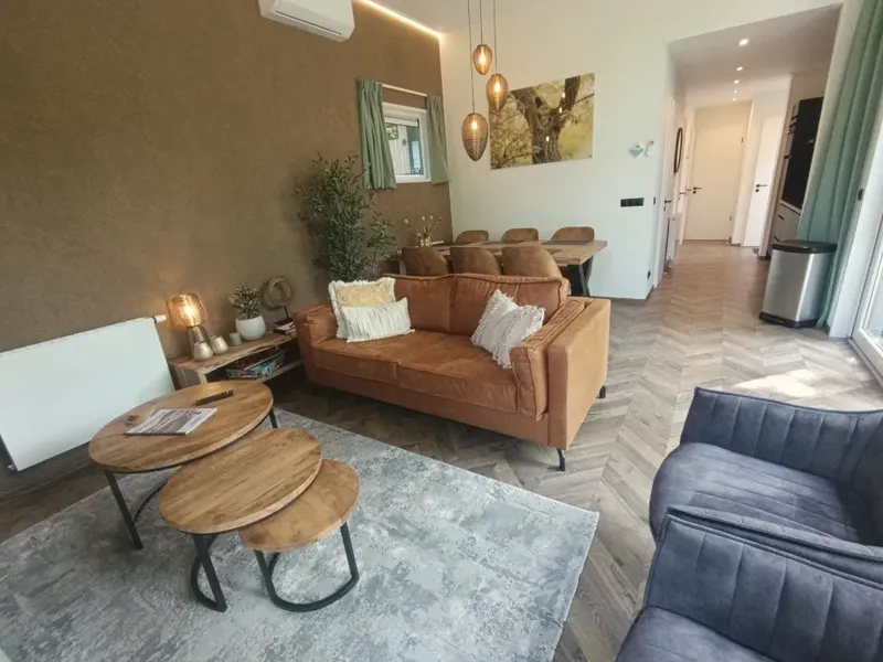 Lichte woonkamer met loungebank en eethoek