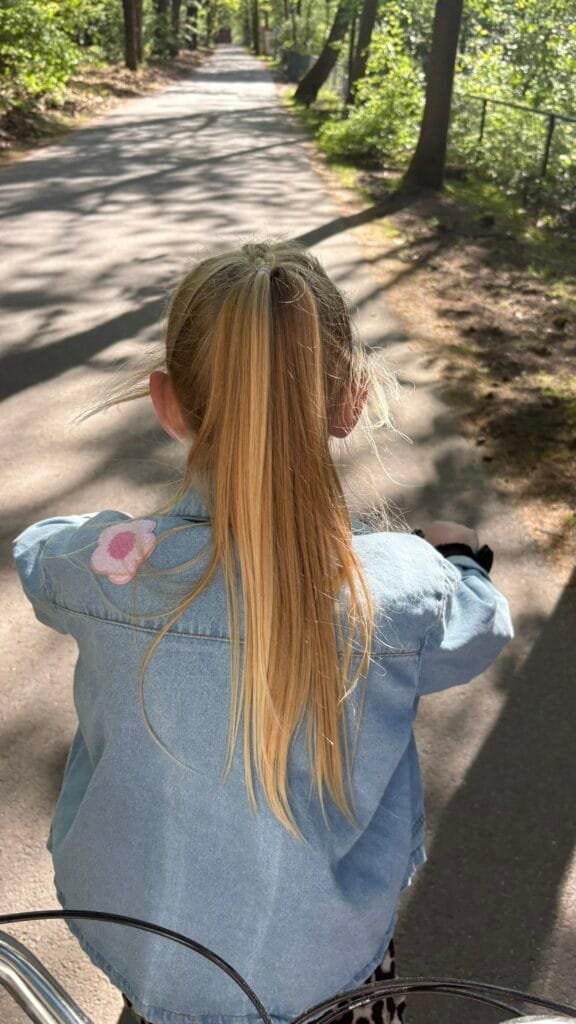 Kind fietst over een zonnig bospad op de Veluwe