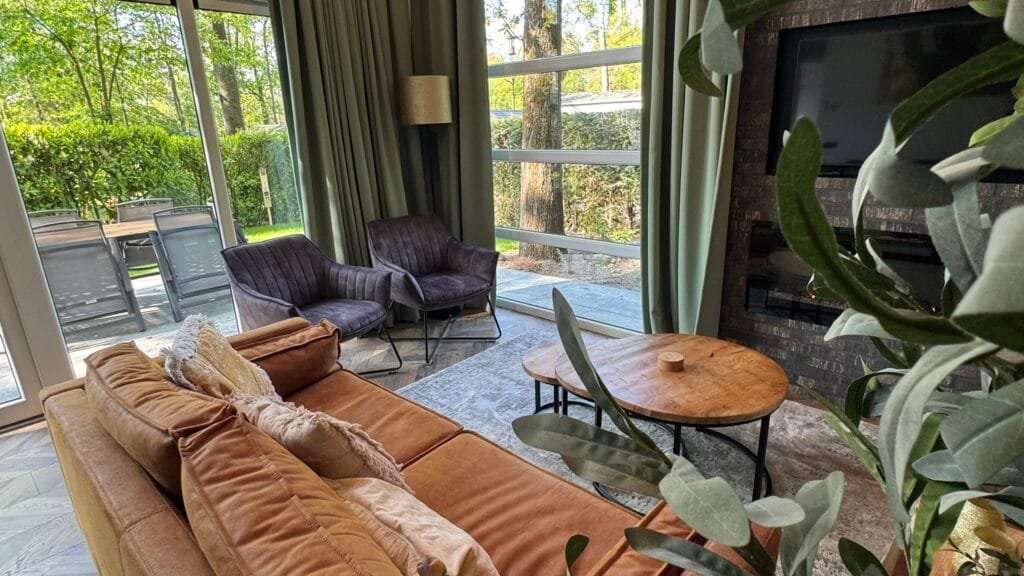 Woonkamer van vakantiehuis Woeste Hoogte 15 met loungebank en uitzicht op de tuin