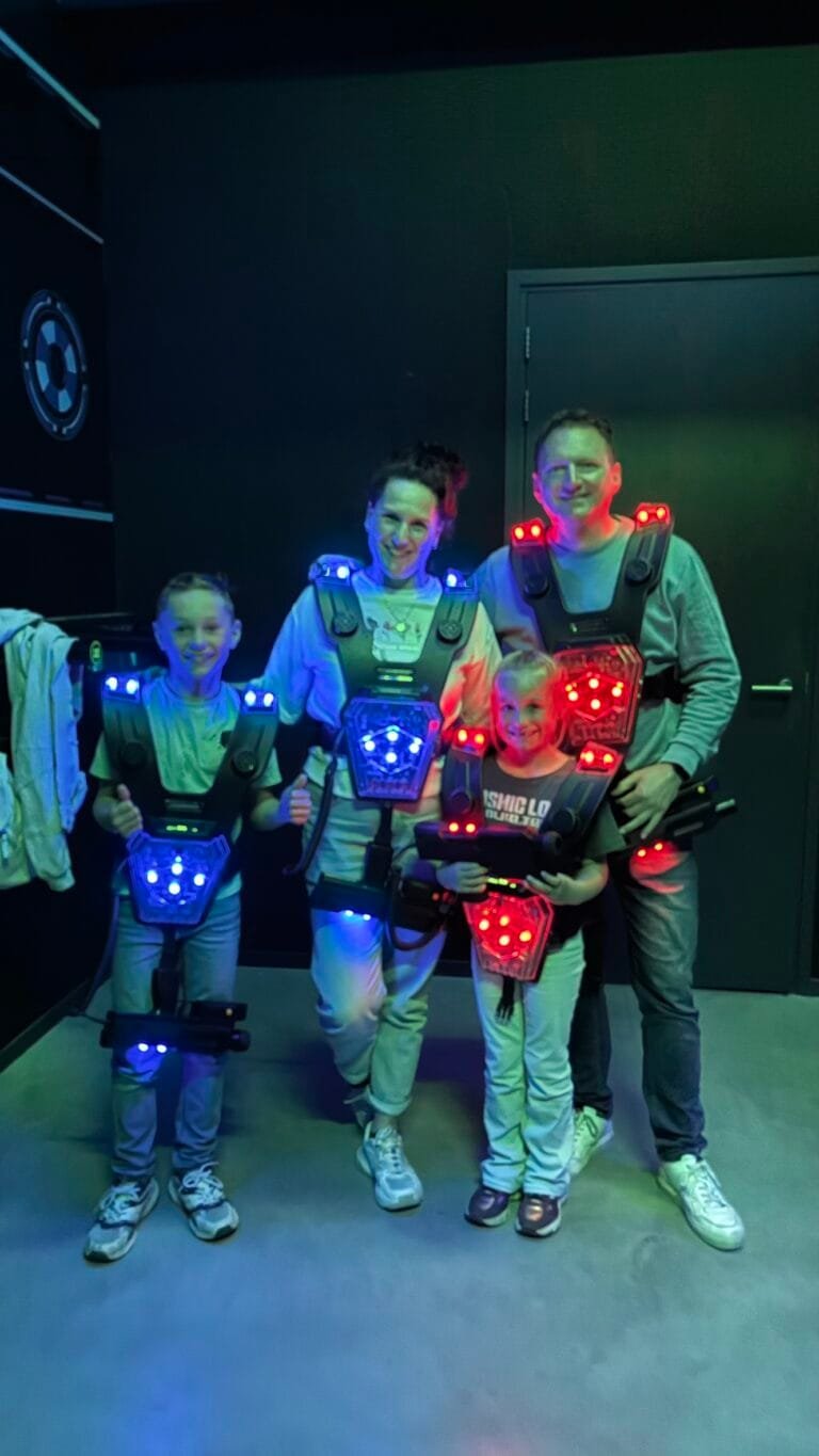 Gezin in lasergame-uitrusting bij ZERO55 in Apeldoorn